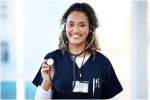 Healthcare professional in dark scrubs smiling while holding a stethoscope chest piece.