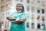 Nurse standing with a building in the background heading to work in the hospital