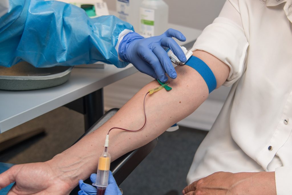 Phlebotomist drawing blood from patient