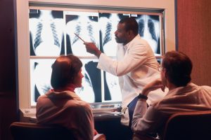 X-ray technician examines chest x-rays